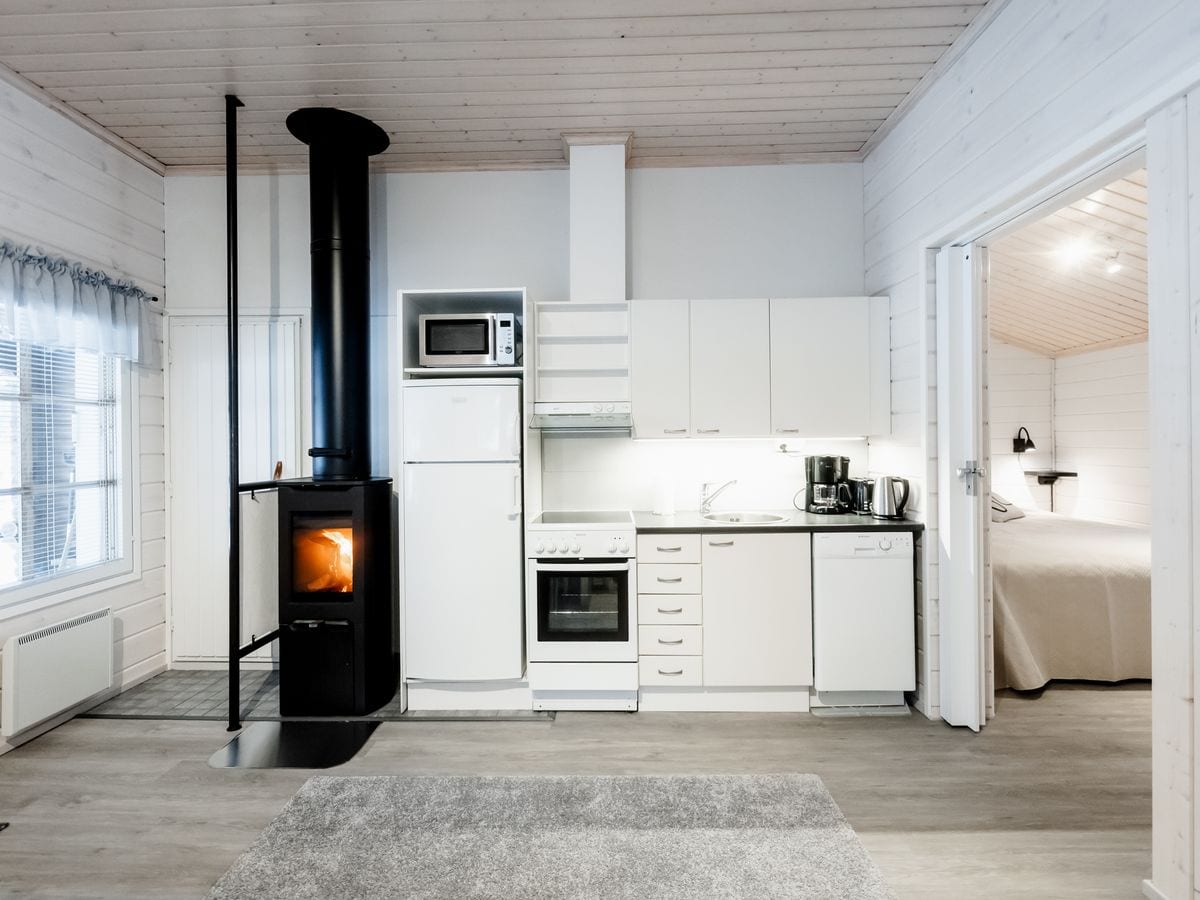 Woonkamer van het huisje met houtkachel en open keuken