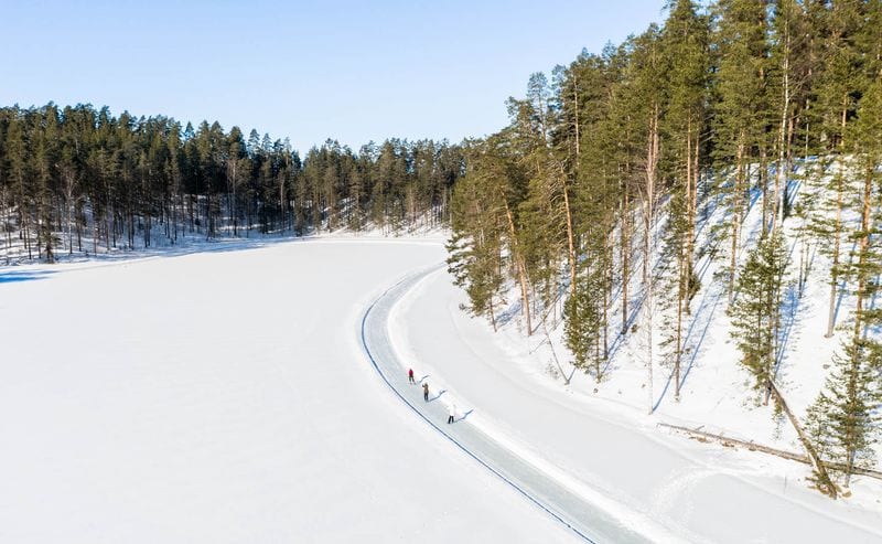 Twee schaatsers in de bocht van de geveegde baan