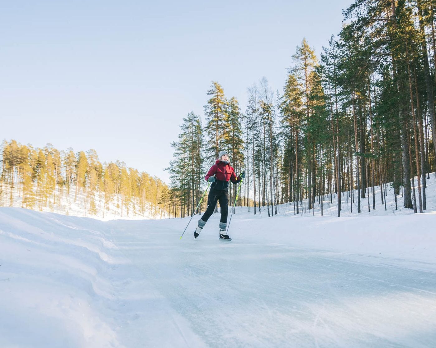 Schaatser op de geveegde baan tussen de sneeuwwallen op het Saimaameer