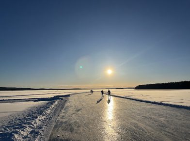 Schaatsers op natuurijs met een laaghangende zon, foto van sander de iongh