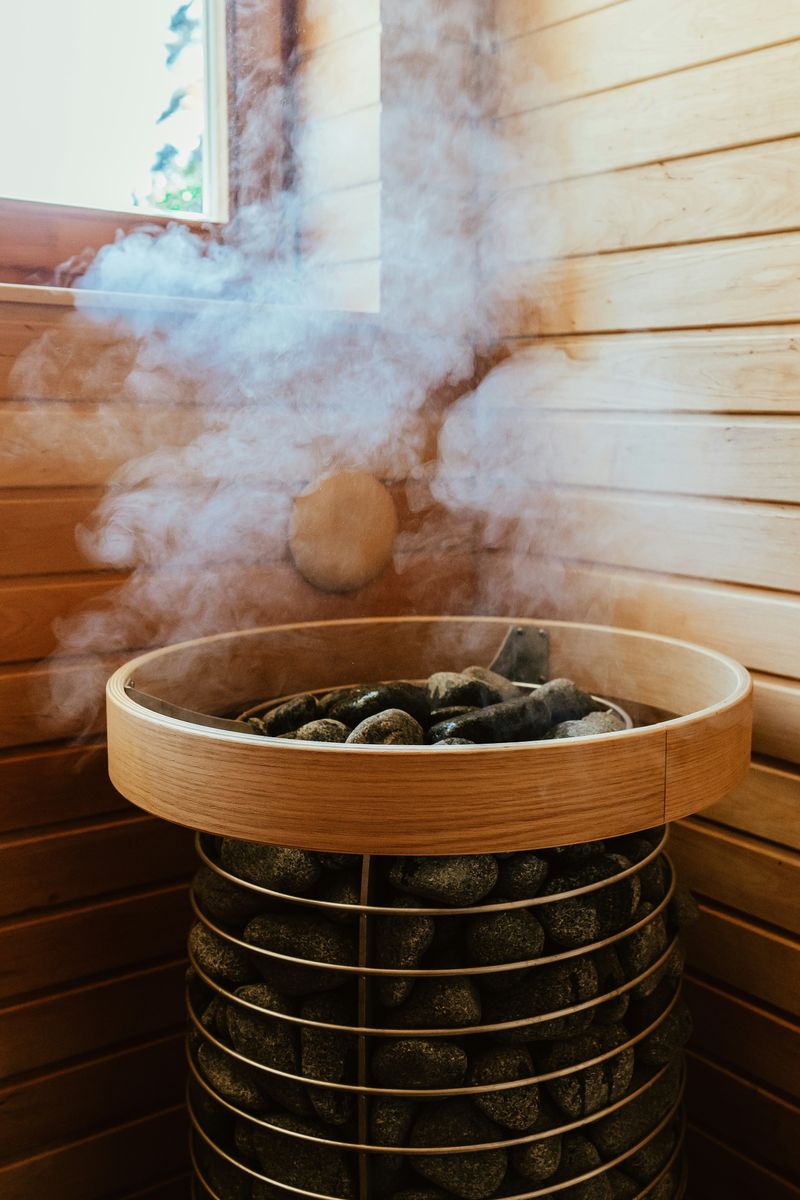 Houten sauna met stoom boven de saunakachel
