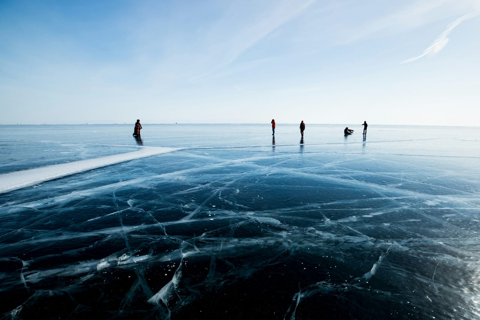 Schaatsers verspreid over glad zwart natuurijs